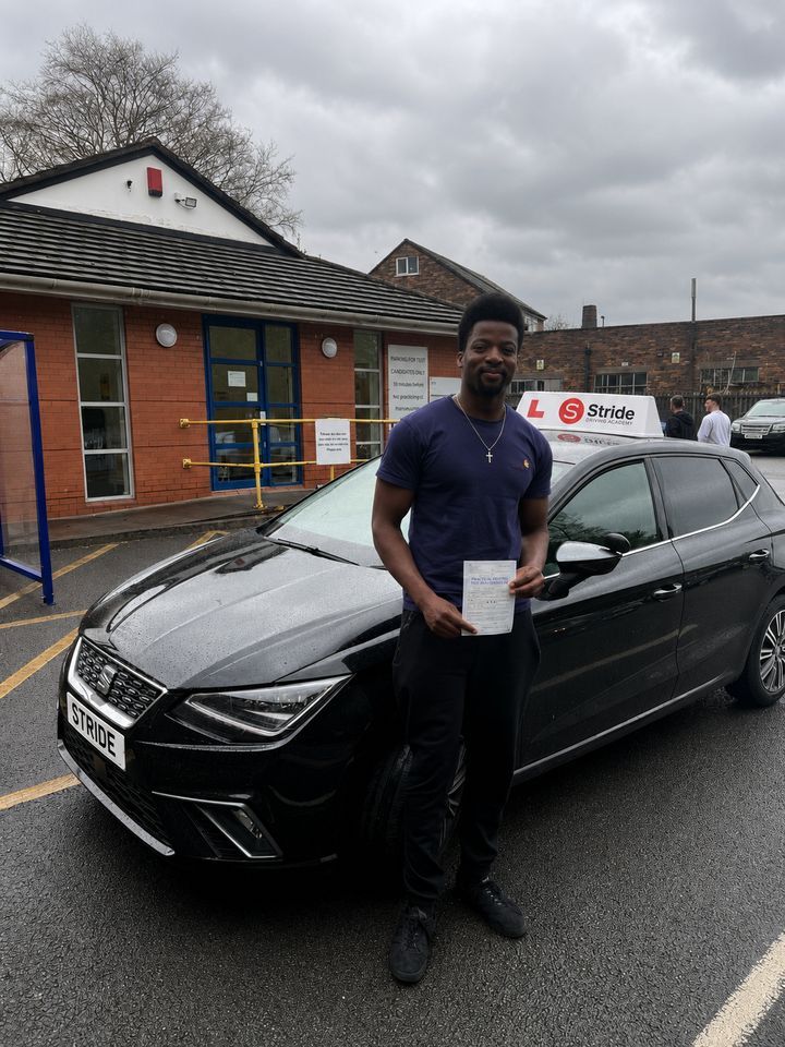 A Stride pupil with their practical driving test pass certificate beside the Stride car