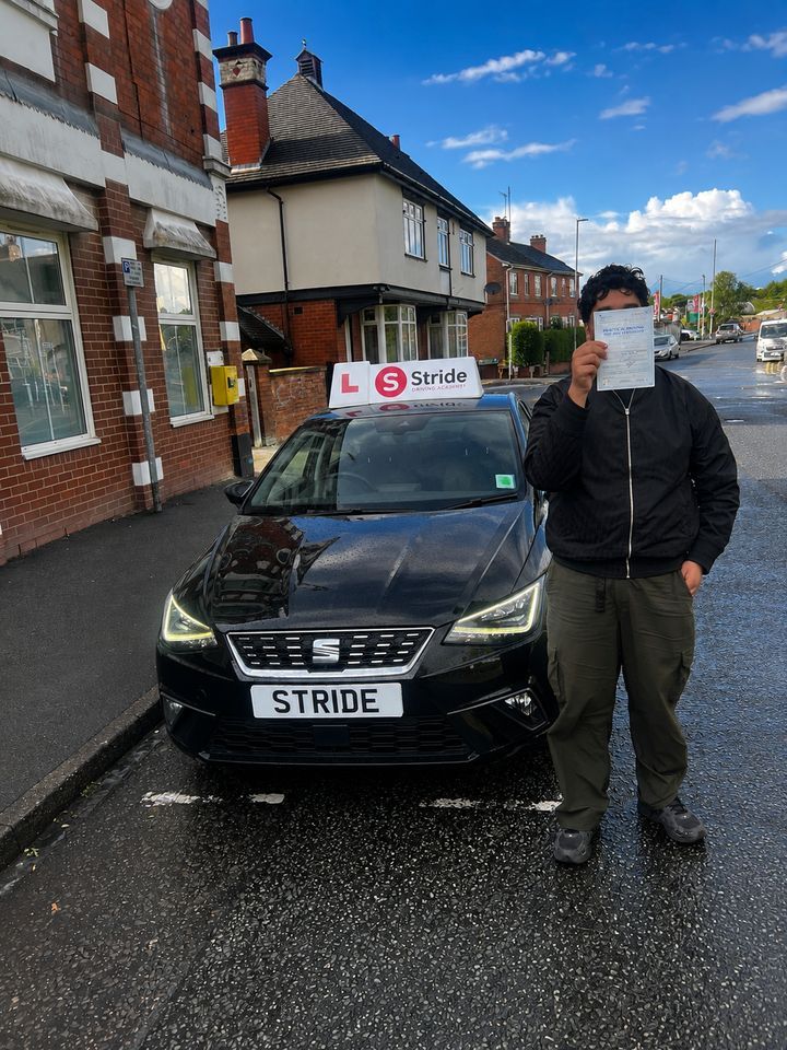 A Stride pupil with their practical driving test pass certificate beside the Stride car