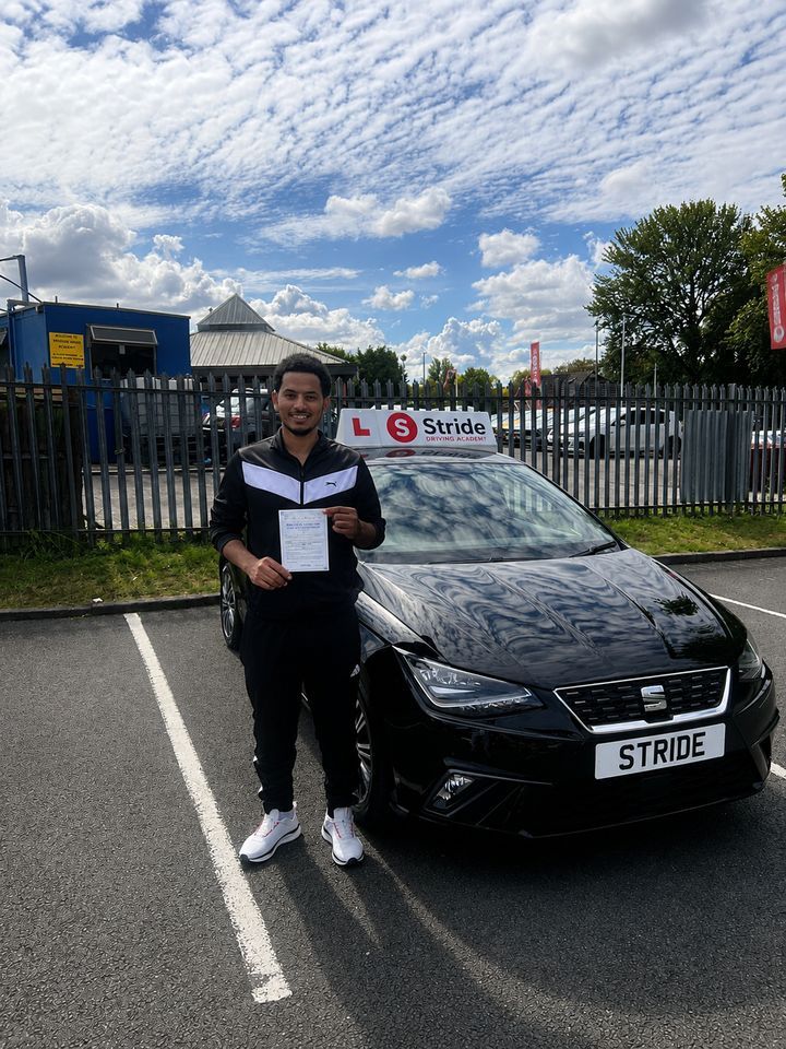 A Stride pupil with their practical driving test pass certificate beside the Stride car